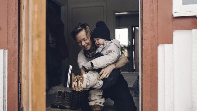 Mother helping daughter wear boot-640x360